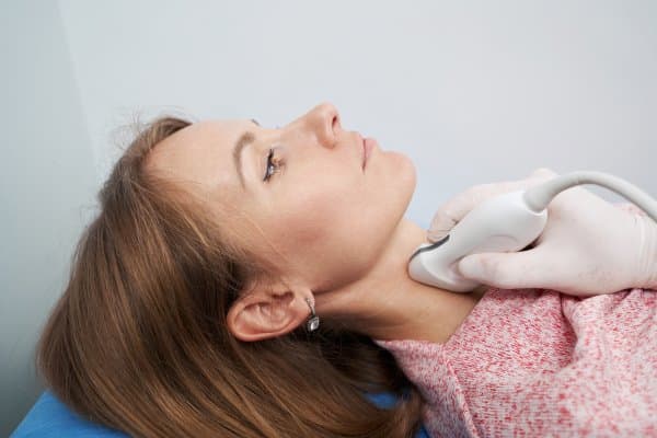 Image of a woman getting her thyroid checked